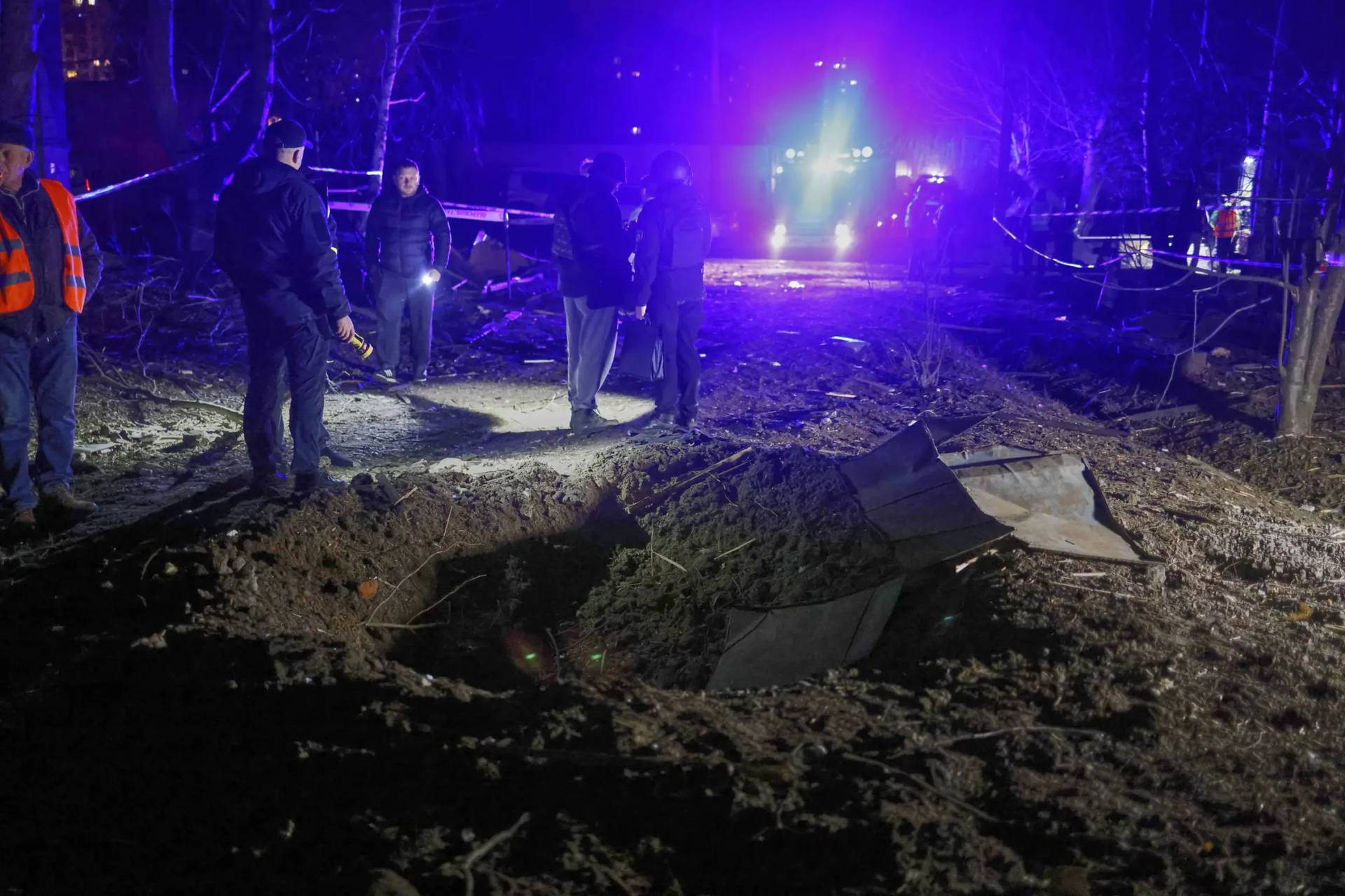 Police officers look at a crater made by a drone near apartment houses following Russia’s night attack in Kharkiv, Ukraine, on March 29, 2025. (Credit: Yevhen Titov/AP.)